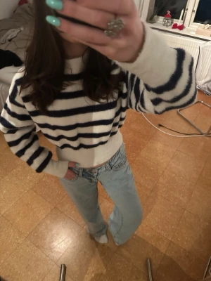 Randig stickad tröja från Bershka - Mysig stickad tröja från Bershka i vitt med mörkblåa ränder. Tröjan har rund halsringning, långa ärmar och ribbade muddar. Superfin och i ett skönt material!!!