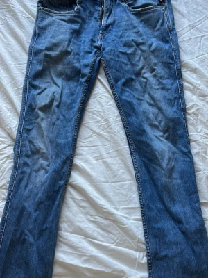 Blå replay jeans  - Säljer ett par klassiska blå bootcut jeans från Levi's med fem fickor och normal midja. Jeansen har en snygg tvätt och är gjorda i slitstark denim. Perfekta för dig som gillar en tidlös och avslappnad stil.