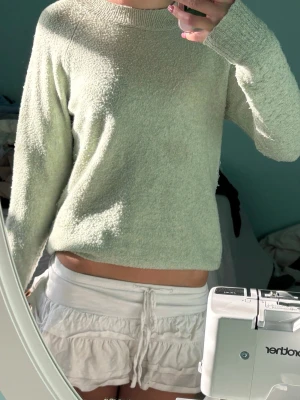 Ljusgrön stickad tröja från veramoda  - Mysig ljusgrön stickad tröja från H&M med rund halsringning och ribbade muddar vid ärmslut och nederkant. Tröjan har en enkel, rak passform och är perfekt för lager på lager. Materialet känns mjukt och behagligt mot huden.