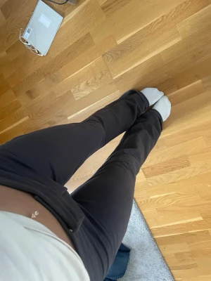 Gråa mjukisbyxor med bootcut  - Säljer ett par gråa mjukisbyxor med utsvängda ben och låg midja. Byxorna har en enkel och clean look utan synliga loggor eller detaljer. Materialet känns mjukt och stretchigt.