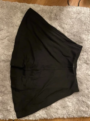 Svart vid kjol  - En enkel och snygg svart kjol med vid passform. Kjolen är ner till knäna på mig och jag är 154cm lång väldigt fin har typ aldrig använt den, resår i midjan, lite oklart vilket märke kjolen är från för jag har fått kjolen 