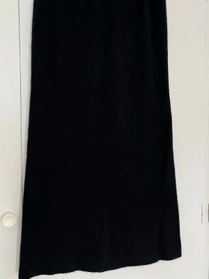 Svart lång stickad kjol - Säljer en svart stickad kjol som tyvärr är för liten för mig. Den är helt oanvänd och i mycket fint skick. Kjolen har ett mjukt och jätteskönt material som känns bekvämt mot huden och passar både till vardag och lite mer uppklädda tillfällen.  Midjan har en stretchig resår som gör att den sitter bekvämt och anpassar sig efter kroppen.  Mått: • Höft: ca 46 cm (platt mått)   • Längd: ca 93 cm  