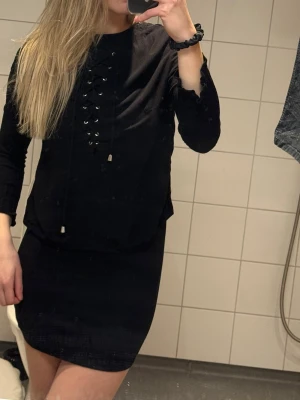 Svart topp H&M  - Svart topp H&M storlek 38. Men liten i storlek. Toppen har trekvartsärm och har snörning. Har ett svart linne och kjol. Annars är de rätt tunt tyg (se bild 4) oanvänd.