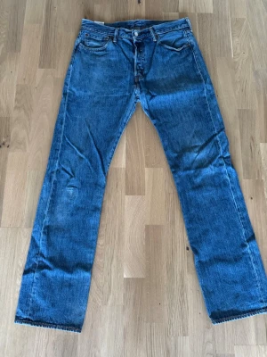 Levi's blå raka jeans 34/34 - Klassiska blå jeans Levi's 501 34/34 ett hål på ena knät som är lagat annars är dom som nya 
