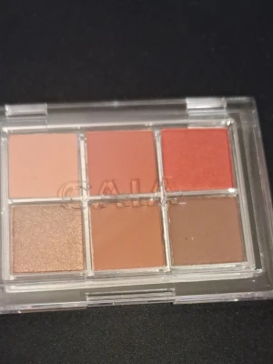 CAIA Heat Wave ögonskuggspalett - Säljer en CAIA Heat Wave ögonskuggspalett med sex nyanser i varma toner: nude, terrakotta, koppar, brons, beige och brun. Paletten har både matta och skimrande skuggor i en smidig plastförpackning med genomskinligt lock. Perfekt för kreativa ögonlooks.