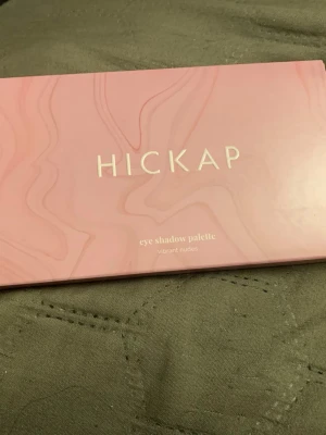 Hickap ögonskuggspalett Vibrant Nudes - Säljer en snygg ögonskuggspalett från Hickap i modellen Vibrant Nudes. Paletten innehåller tolv olika nyanser i både matta och skimriga toner, med färger som brunt, guld, koppar, beige och nude. Kommer i en rosa förpackning med spegel inuti.
