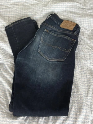 Mörkblå slim fit jeans Polo Ralph Lauren 30/32 - Snygga mörkblå slim fit jeans från Polo Ralph Lauren köpta i USA med klassisk femficksdesign och läderpatch bak i midjan. Jeansen har diskreta slitningar och kontrastsömmar för en modern look. Perfekta till en avslappnad stil.