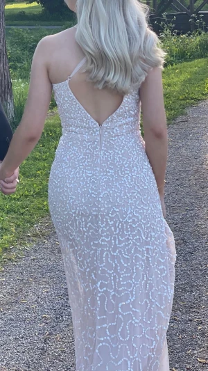 Ljusrosa långklänning med paljetter och öppen rygg - Säljer min otroligt fina ljusrosa balklänning 🌸Tunna axelband som korsar i ryggen, öppen rygg. Massa paljetter som glittrar fint i solen ✨ Bara använd 1 gång. Köpt på asos för 1700kr. Storlek 34/XS 