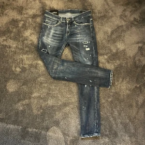 Dondup George skinny jeans blå - Snygga blå jeans från Dondup, modell George Skinny Fit. De har slitna detaljer, blekta partier och coola små revor för en edgy look. Klassisk femficksdesign, smal passform och tillverkade i stretchig denim för extra komfort. Köptes på Nääs fabriker för runt 4000. Använd fåtal gånger, nyskick. De här byxorna är otroligt limiterade. Skriv vid intresse👍