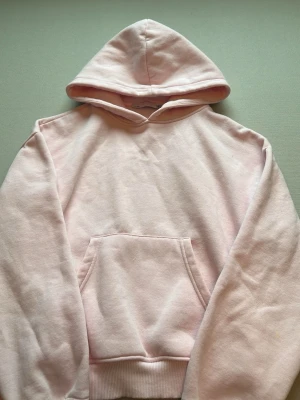 Ljusrosa hoodie med magficka - Säljer en ljusrosa hoodie från lager 157🩷 Supermysig och skön, insidan har ett mysig fluffigt material. Hoodien har 2 små gula fläckar vid vänster arm men inget man ser tydligt eller tänker på (kolla sista bilden), använd några gånger under kort tid. Minns inte det köpta priset