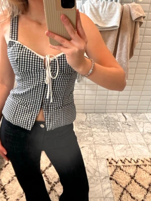 Rutig svartvit korsettopp med snörning - Säljer denna superfina korsettopp i mörkblå/vit rutigt mönster. Från Zara och helt slutsåld!  Storlek S. Pris kan diskuteras vid snabb affär, hör av er vid intresse🥰🥰 