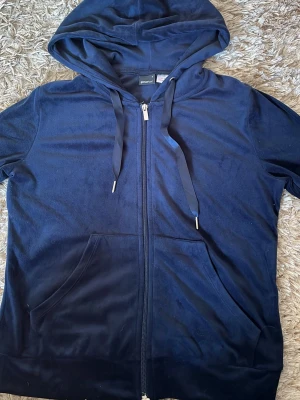 Mörkblå velour hoodie med dragkedja - Mysig mörkblå hoodie i mjuk velour från Gina tricot. Tröjan har dragkedja framtill, två fickor och justerbar huva med breda snören. Perfekt för en avslappnad och trendig look.