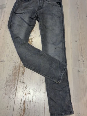 Gråa slim fit jeans från replay  - Säljer ett par gråa slim fit jeans från replay med klassisk femficksmodell och svarta detaljer på bakfickan. Jeansen har en tvättad look och raka ben. Perfekta för en avslappnad och trendig look. Hör av dig vid minsta fundering😃Längden är 96cm och midjan 76cm.