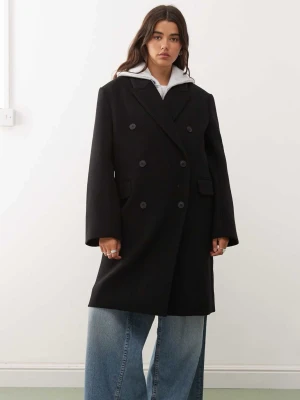 Svart dubbelknäppt ullkappa - Stilren svart kappa med dubbelknäppning och breda slag. Tillverkad i ullblandning som ger en klassisk look och passar perfekt till lager-på-lager. Enkel att matcha. Den är helt ny med prislapp kvar. orginalpris är 1200. 