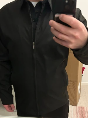 Overshirt/vårjacka - Stilren svart overshirt med dragkedja. 