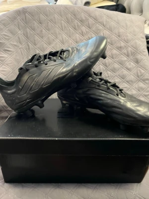 Adidas Copa fotbollsskor - Säljer ett par helsvarta fotbollsskor från Adidas Copa med klassisk design och snörning. Perfekta för dig som vill ha stilrena bekväma och funktionella skor på planen.