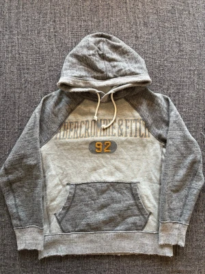 Abercrombie & Fitch hoodie ~ sjukt sällsynt  - Säljer en eftertraktad grå hoodie från Abercrombie & Fitch. Vintage 2000’s-modell med sliten design | storlek S | skick 8/10 | svår att hitta idag och ger en riktigt snygg Y2K-look. Kan även gå ner lite i pris vid snabb affär.
