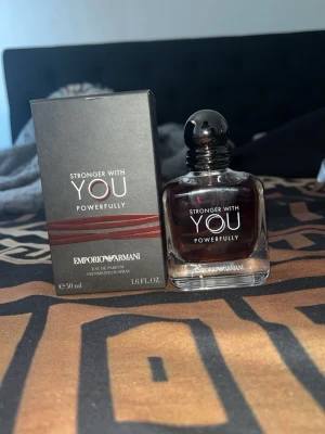 Emporio Armani Stronger With You parfym - Emporio Armani Stronger With You Powerfully är en elegant parfym i en stilren glasflaska med mörkröd doftvätska. Flaskan har rundade former och svart spraykork. Förpackningen är svart med silver- och röda detaljer. Volymen är 50 ml.