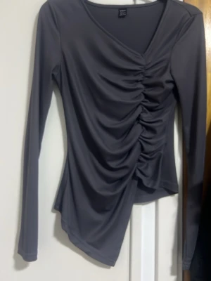 Grå långärmad topp med snörning - Säljer en mörkgrå långärmad topp med v-ringning 😍