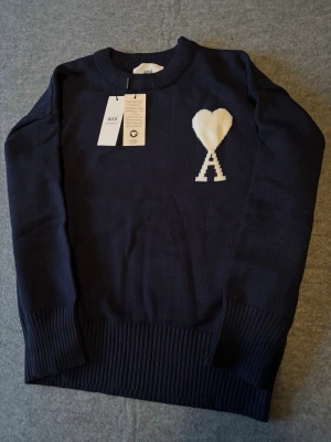 Mörkblå stickad tröja från Ami - Helt ny mörkblå AMI tröja, storlek S men passar utmärkt för XS. Aldrig använd och kommer med originalförpackning samt taggar och fungerande QR kod. Skriv vid minska fundering, eller om du vill ha fler bilder-jag svarar så snabbt som möjligt.