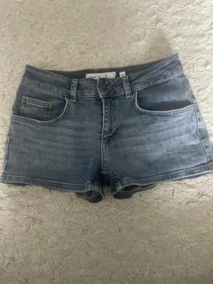Blå jeansshorts från subdued - Säljer dessa shorts från subdued. De är lågmidjade och sitter tajt på låren och är korta. Säljer shorten för att de it e kommer till användning. Köpt förra sommaren. Inget slitage. 