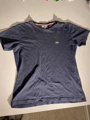 Blå t-shirt från Lacoste - Passar cirka 152 cm