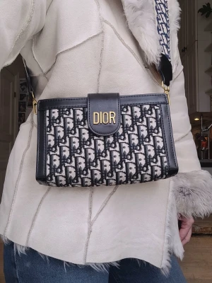 Läcker väska axelremsväska crossbody trend populär - Så snygg!! Älskar denna, dock knappt använd så den är riktigt fin och fräsch, har dock haft den med flera andra saker ovanpå i ett förråd så sidorna har blivit lite spruckna men är ej några hål och forsatt väldigt snygg 