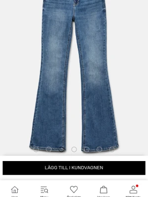 Blå bootcut jeans med slitningar - Säljer ett par blå bootcut jeans. Jeansen har en utsvängd passform från knät och ner, vilket ger en retroinspirerad look. Tillverkade i denim med snygg tvätt och normal midja. Medelhög midja!