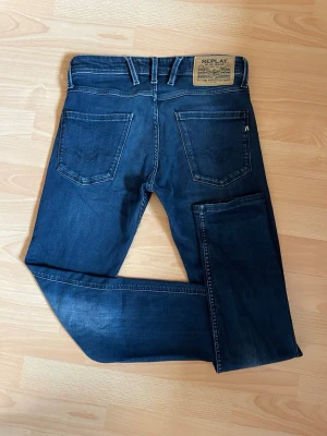 Mörkblå jeans från Replay - Snygga mörkblå jeans från Replay med klassisk femficksdesign och raka ben. Jeansen har tydliga kontrastsömmar och en stor Replay-lapp bak i midjan. Tillverkade i slitstark denim som ger en tidlös look.