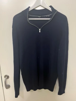 Mörkblå halvzip tröja från jack & jones - Snygg mörkblå stickad tröja från jack & jones med halvzip-dragkedja vid halsen. Tröjan har lång ärm och en klassisk, stilren design som passar perfekt till jeans eller chinos. Materialet känns mjukt och bekvämt, perfekt för lager på lager.