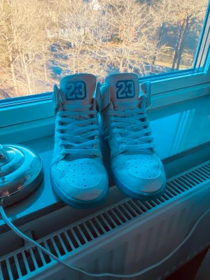 Jordan 1 max flight 23 - Snygga höga sneakers från Jordan i vitt med blå detaljer och siffran 23 på plösen. Skorna har en blå sula, perforerade partier för ventilation och klassisk snörning. Tillverkade i läder med cool retrostil som sticker ut.