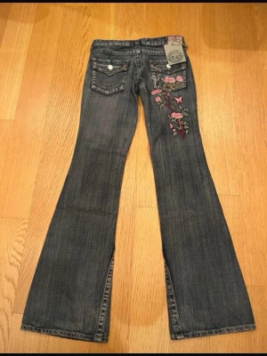 Sällsynta & unika true religion bootcut jeans - Säljer ett par unika och sällsynta grå-blå bootcut jeans från True Religion. Äkta vintage från 2005, i nyskick med lapp kvar. Finns ej att hitta nånstans längre! Storleken är w28 men de sitter mindre än så tycker jag, brukar komma i w26/27 men kommer ej i dessa!! Mått i cm finns på sista bilden 💕