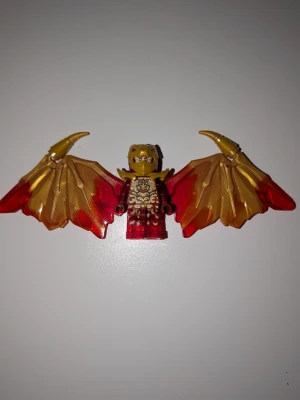 LEGO Ninjago Kai Golden Dragon minifigur🔥 - SÄLLSYNT Ninjago Kai Crystalised Golden Dragon LEGO-figur med stora, röd-guldiga vingar och detaljerad rustning🔥. Figuren har ett drakliknande huvud i guld och rött, samt eldiga mönster på kroppen. Perfekt till samlingen eller som cool dekoratation. Perfekt skick och värdet på figuren är mellan 250-300kr.💯                                                Priset kan diskuteras💲