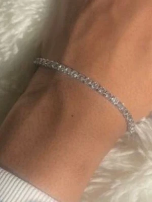 Glittrigt silverfärgat armband - Säljer ett tunt och elegant armband i silverfärg med gnistrande stenar som ger en lyxig känsla. Armbandet har en klassisk design med små, tätt sittande stenar som reflekterar ljuset snyggt. Perfekt för dig som gillar stilrena accessoarer med extra bling.