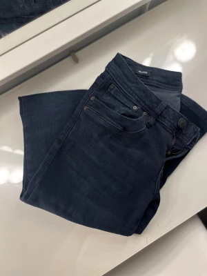 Mörkblå skinny jeans från LTB - Säljer ett par mörkblå skinny jeans från LTB med klassisk femficksdesign och normalhög midja. Jeansen har stretchigt material för skön passform och subtila slitningar för en trendig look. Perfekta till vardags och lätta att matcha med olika stilar.