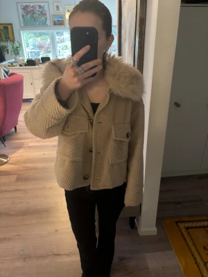 Beige jacka med fuskpäls-krage - Säljer en beige kappa med pälskrage. Säljer för den inte kommer till användning längre, använd fåtal gånger. Nypris är 800kr priset kan diskuteras.