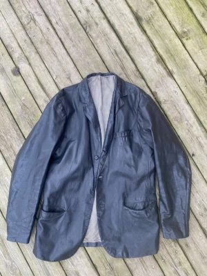 Malung läderkavaj 60-tal - En skinnkavaj från Malung. Läder i mycket fint skick. Innerfoder skulle behöva bytas/tvättas, se bild. Saknas även 2 knappar. En fin jacka som är värd att satsas på, från 60-talet. Storlek M i normal och rak passform.