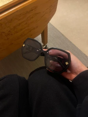 Svarta  solglasögon - Säljer ett par svarta solglasögon Sidorna har den klassiska guldiga dekorativa detaljer. Riktigt statement-piece för dig som vill sticka ut.