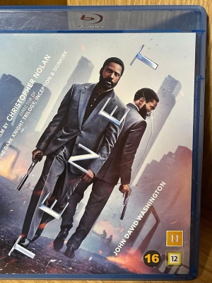 Tenet Blu-ray - Säljer Blu-ray-utgåvan av filmen Tenet, regisserad av Christopher Nolan. Omslaget är blått med futuristiskt motiv och tydlig titel. Filmen är på svenska och engelska, rekommenderad från 16 år. Perfekt för dig som gillar action och sci-fi.
