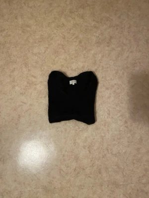 Svart stickad tröja med v-ringning - En enkel och stilren svart stickad tröja med v-ringad hals och långa ärmar. Tröjan är tunnstickad och har en kroppsnära passform, perfekt att matcha med jeans eller kjol. Materialet ser mjukt och bekvämt ut.