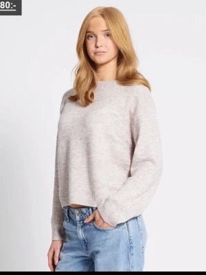 Beige stickad tröja  - Mysig beige stickad tröja från 157 med avslappnad passform och rund halsringning. Tröjan har långa ärmar och är tillverkad i ett fluffigt, mjukt material som ger en chill vibe. Perfekt att matcha med jeans eller vida byxor.