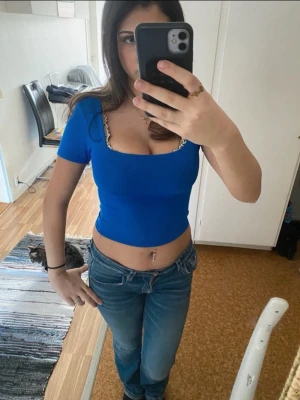 Blå croppad topp med kort ärm - Snygg croppad topp i kornblå färg med korta ärmar och fyrkantig urringning. Toppens passform är tight och den är perfekt för dig som vill ha en enkel men färgstark look. Materialet känns stretchigt och bekvämt.