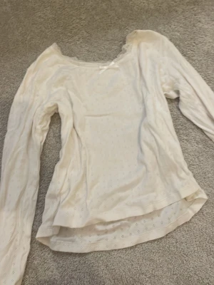 Vit spetsblus från H&M - Söt vit blus från H&M med lång ärm och diskret hålmönster. Blusen har spetsdetaljer vid halsringningen och är tillverkad i ett mjukt, tunt material som känns luftigt och bekvämt. Perfekt för dig som gillar en romantisk och enkel stil. storlek 146/152🤞🏼❤️