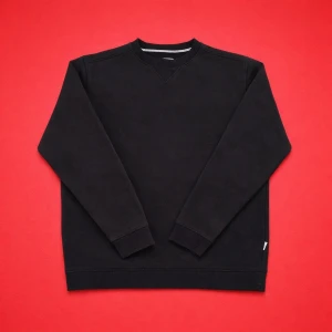 Svart  tröja med rund hals - En stilren svart  tröja med rund halsringning och långa ärmar. Tröjan har ribbade muddar vid ärmslut och nederkant samt en diskret detalj vid halsen. Perfekt basplagg för garderoben.