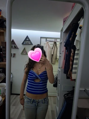 Blåvit randig croppad linnetopp - Säljer en blå och vit randig croppad linnetopp utan axelband och en snygg cut-out detalj framtill. Toppen har en figurnära passform och är perfekt för varma dagar. Supersnygg att matcha med jeans eller kjol! Aldrig använd.