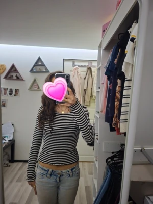 Svartvit randig långärmad tröja - Säljer en svartvit långärmad tröja med smala horisontella ränder. Tröjan har ett sjönt material och rund halsringning. Perfekt till jeans för en avslappnad och trendig look.