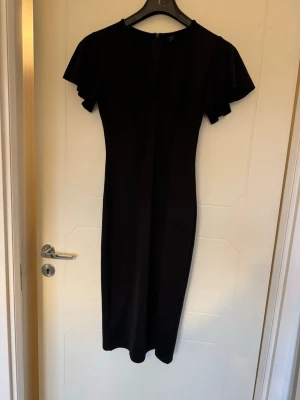 Svart kroppformad klänning - Otroligt snygg klänning, formar kroppen jätte snyggt med en liten slits vid ena låret och en fin urringning. Använd enstaka gånger men fortfarande i fint skick.