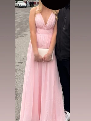 Ljusrosa balklänning med slits - Ljusrosa balklänning med v-ringning,  markerad midja och kors i ryggen. Klänningen har en slits framtill. Perfekt för bal eller studentbal💞pris kan diskuteras