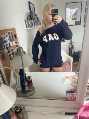 Mörkblå GAP hoodie med tryck - Snygg mörkblå offshoulder från GAP med stort vitt tryck på bröstet. 