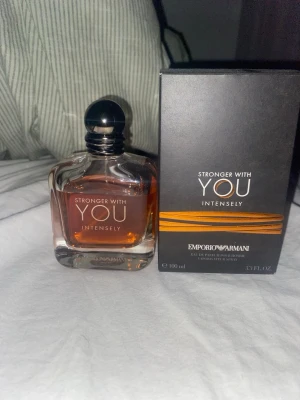  Stronger With You Intensely - Emporio Armani Stronger With You Intensely är en parfym för honom med en elegant, fyrkantig glasflaska och svart rund kork. Doften har en varm bärnstensfärgad vätska och kommer i en stilren svart förpackning med guldiga detaljer. Flaskan rymmer 100 ml. JAG KAN INTE SKICKA INNAN 1 APRIL,  EFTER DET GÅR BRA.       CA 80ml kvar